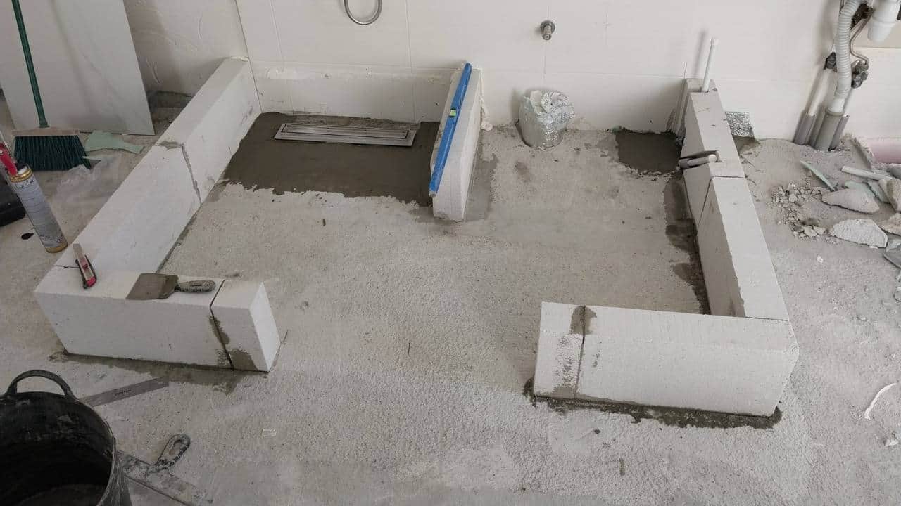 Cuvă de duș zidită din blocuri BCA în jurul unei rigole liniare deja montate, pe șapă proaspătă.